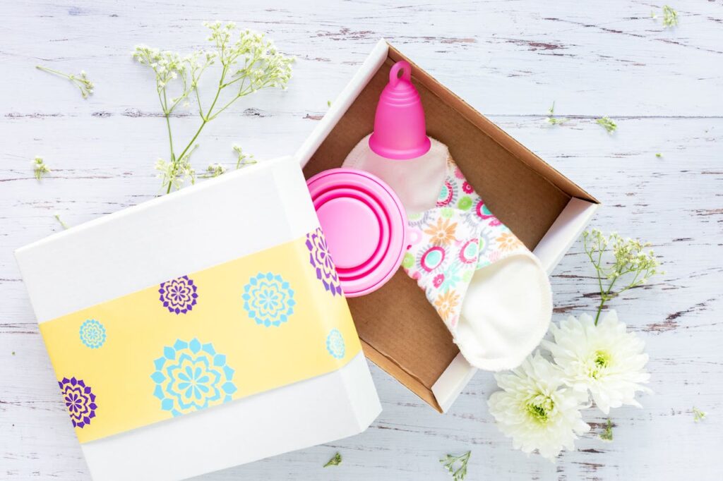 Crafting Captivating Headlines: Your awesome post title goes here Brightly decorated gift box containing reusable menstrual cup and pads on a rustic background.